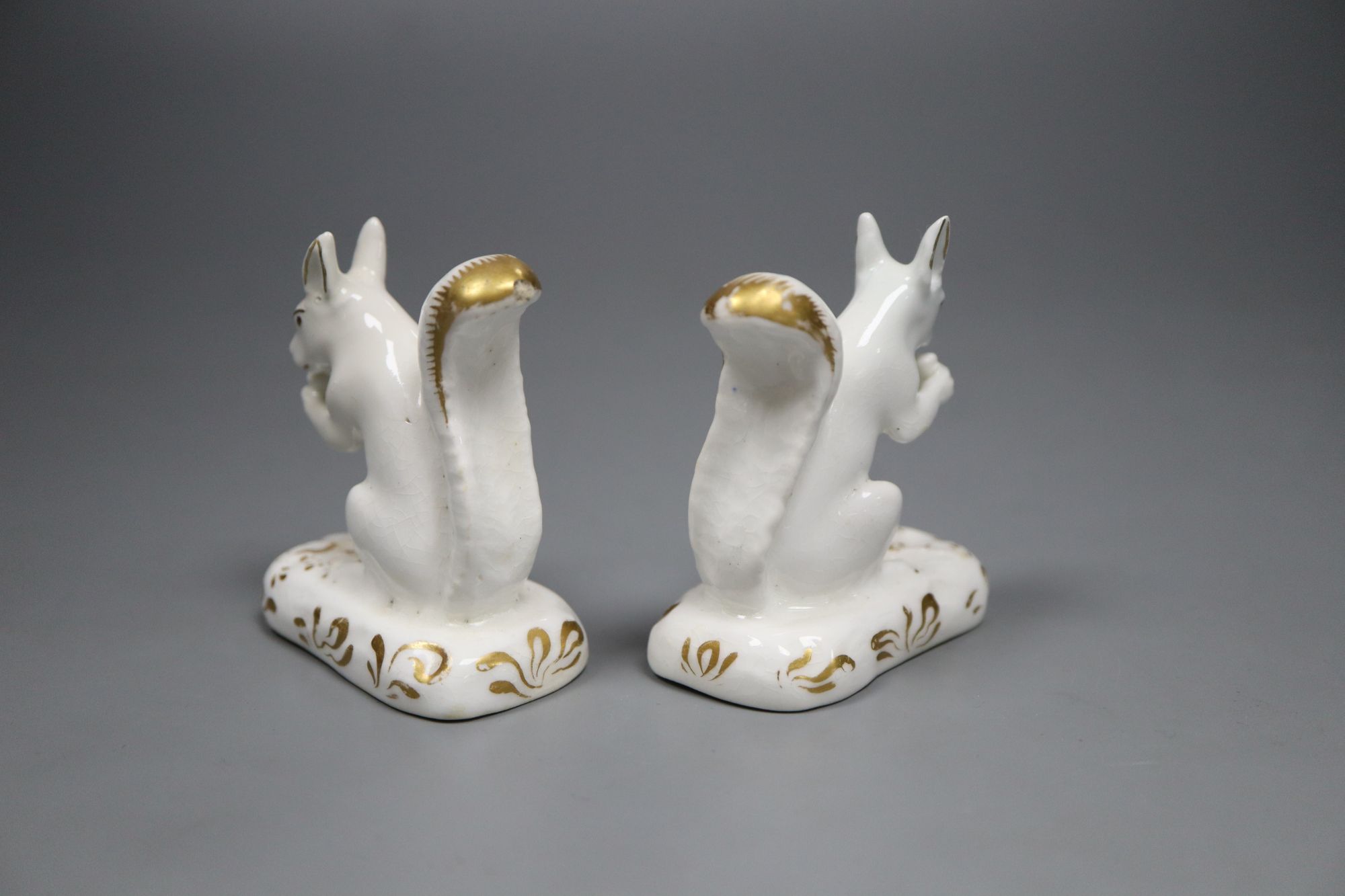 A pair of Grainger, Lee & Co. gilt and white porcelain figures of squirrels, c.1820-37, 6.5cm high